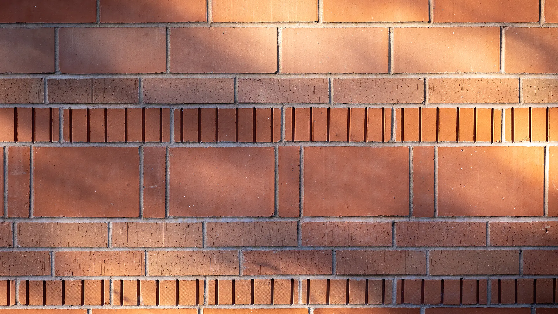 Un mur de brique rouge du Vieux-Lille dans le soleil rasant du soir