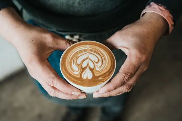 Un latte tenu à deux mains — Agrandir