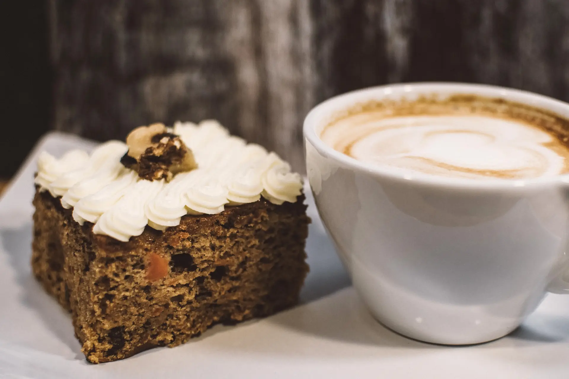 Un carré de carrot cake glacé, une tasse de café au lait